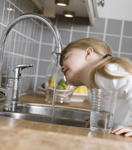 niña bebiendo agua del grifo